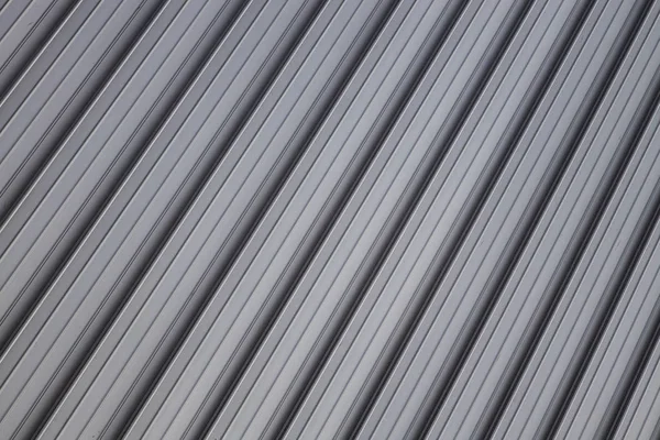 Angle view at gray corrugated metal wall or fence surface. — Stock Photo, Image