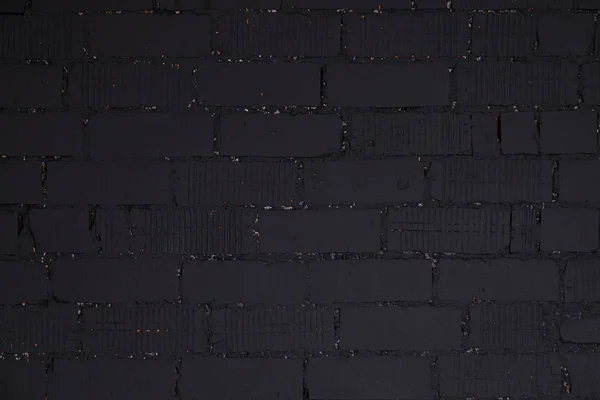Irregular black brick wall with black cement in gaps — Stock Photo, Image