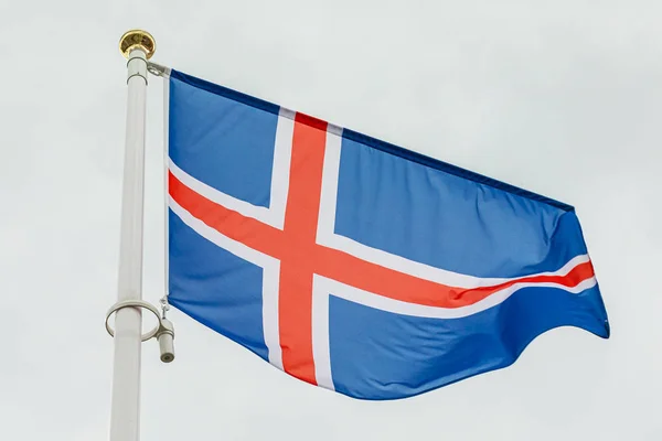 Bandeira islandesa acenando ao vento contra o céu — Fotografia de Stock