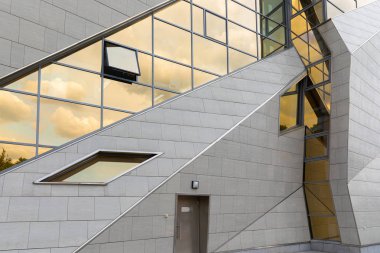 Yüksek modern bina şık dış tasarım düşük açı görünümü, lüks sınıf. pencerelerde gökyüzü yansıması ile eve giriş kapısı.