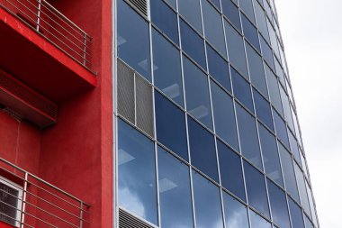 Modern iş merkezi cam cephe ve balkon ve gökyüzü arka plan ile turuncu duvarların düşük açı görünümü