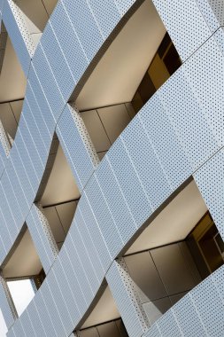 Geniş pencere deliği alanı ve lounge bölgesi ile fütüristik bina metal delikli cephe diyagonal görünümü. Eko tasarım, dış. Akan şekil
