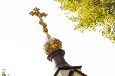 Yaldızlı güneş ışığının kilisenin tepesinde beyaz güneşli gökyüzüne ve ağacın tepesine yakın çekim.