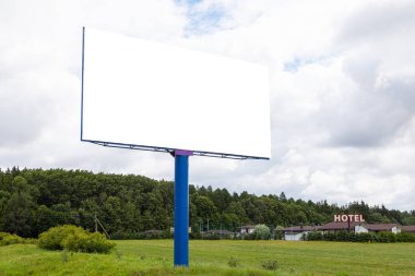 Arka planda otoban ve motel boyunca büyük boş bir reklam panosu.