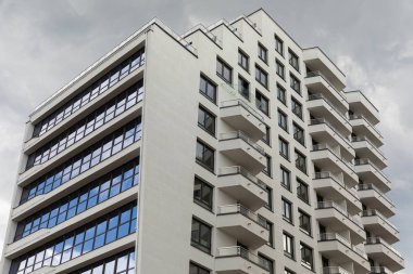Geniş cam pencere ve balkon ile çağdaş yüksek apartman binalarının dış görünümü.