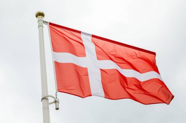 Kırmızı arka plana karşı beyaz haç ile Danimarka bayrağı