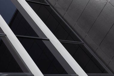 Siyah cam duvara yakın çekim ve pürüzlü fayanslarla kaplı siyah duvar.