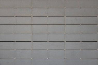 Küçük metal fayanslardan yapılmış açık gri duvarın ön görüntüsü