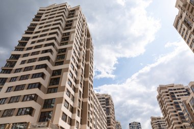 Güneşli bir günde mavi gökyüzü arka planındaki çok katlı modern apartmanların zemin görüntüsü.