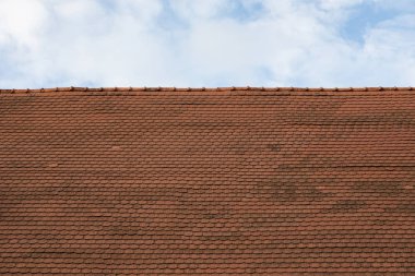 Kırmızı metal çatıyı mavi gökyüzüne karşı kiremitliyor