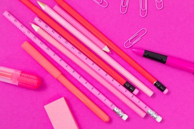 Pembe renkli ofis kırtasiyesi pembe yüzey kesimine saçılmış.