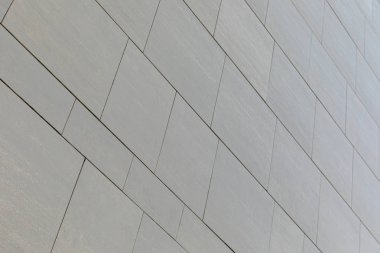 Farklı şekilli gri pürüzsüz fayanslara sahip duvarın düşük açılı görünümü (dikdörtgen ve kare)