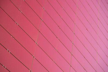 Sağ köşeli küçük metal levhalardan yapılmış kırmızı metal bir binanın zemin manzarası. Alanın derinliğine sahip fotoğraf