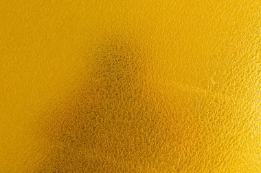 Altın renginde sert bir yüzey, fotoğrafçının gölgesi..