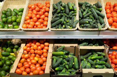 Hasır sepetli süpermarket tezgahı ve domatesli karton kutular, salatalık ve avokado.