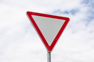 Yol işaretinin yakın çekimi gökyüzüne karşı yol verimi