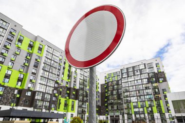 Yol işareti Mavi gökyüzüne karşı apartman bloğunun avlusunda trafik yok