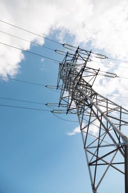 Gökyüzüne ve bulutlara karşı yüksek elektrik direği. Dikey resim