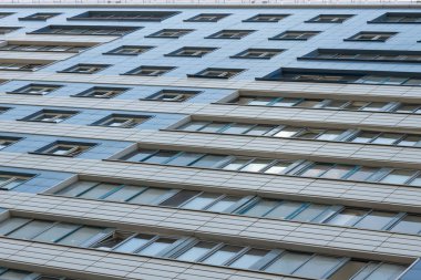 Duvarda mavi ve bej karolar ve büyük geniş pencereler ile yüksek binanın zemin görünümü.