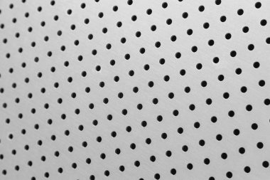 Yuvarlak delikli düz duvardan oluşan beyaz metal yüzeye yakın plan. Alanın derinliğine sahip fotoğraf