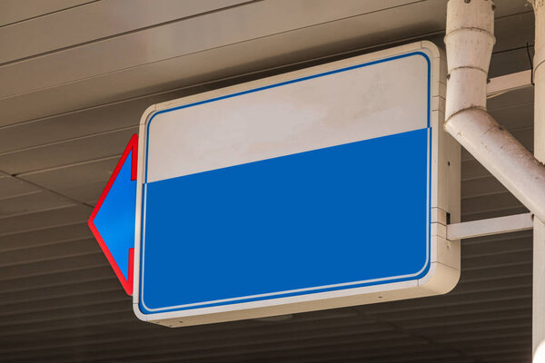 Close-up of blank white and blue sign with pointer on left