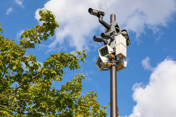 Videocámaras Seguridad Farolas Blancas Una Columna Contra Cielo Hojas Verdes — Foto de Stock