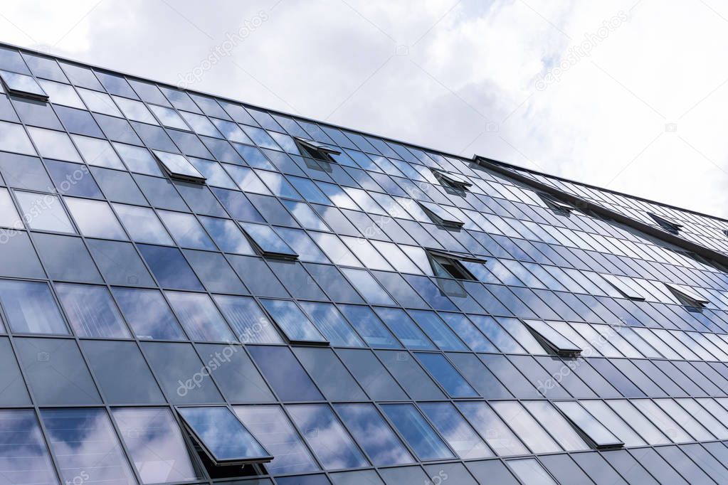 Glass building facade with open windows, business centre architecture.