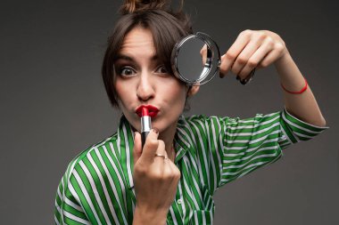 Güzel esmer kadın makyaj yapıyor. 