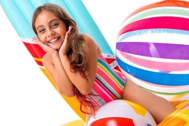 Plaj tarzında beyaz arka planda poz veren tatlı küçük kız.  