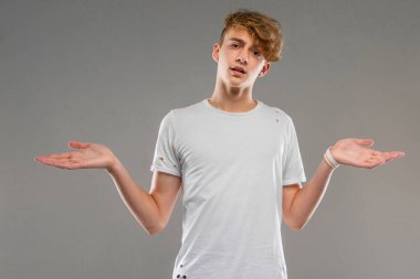 Yakışıklı duygusal genç stüdyoda griye karşı poz veriyor. 