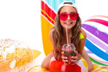 Plaj tarzında beyaz arka planda poz veren tatlı küçük kız.  