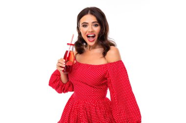 Kırmızı elbiseli kadın beyaz arka planda içecekle poz veriyor. 