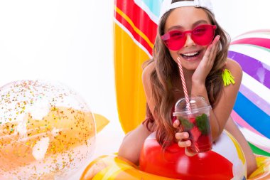 Plaj tarzında beyaz arka planda poz veren tatlı küçük kız.  