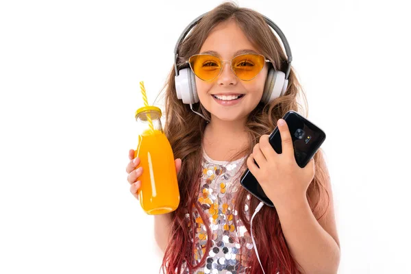반짝이는 드레스를 노란색 선글라스를 커다란 이어폰을 음악을 핸드폰을 오렌지 주스를 — 스톡 사진