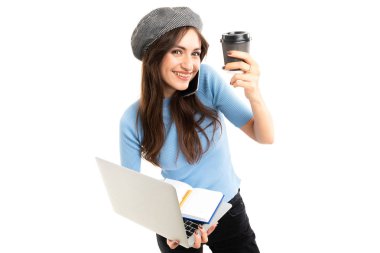 Dizüstü bilgisayarı ve kahvesi olan meşgul bir kadın. 