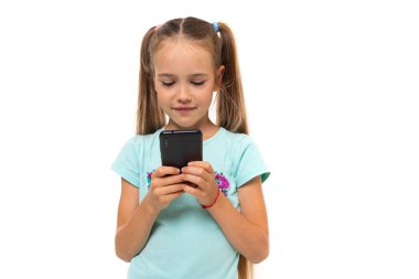 Cep telefonu olan küçük kız beyazda izole edilmiş. 