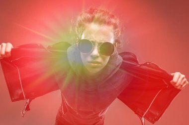 Deri ceketli, güneş gözlüklü, esmer bir bayan.