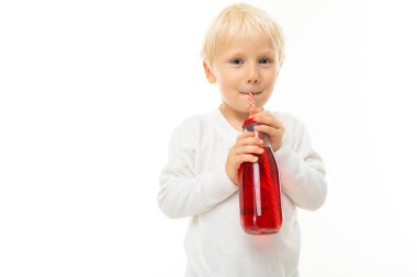 Beyaz arka planda içecekle poz veren küçük çocuk. 