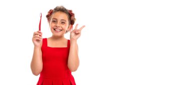 Beyaz arka planda diş fırçasıyla poz veren sevimli küçük kız.  