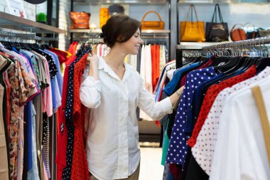 Mağazada kıyafet seçen güzel bir kadın. 