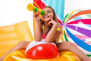 Plaj tarzında beyaz arka planda poz veren tatlı küçük kız.  