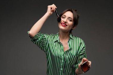 Güzel esmer kadın makyaj yapıyor. 