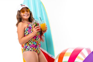 Plaj tarzında beyaz arka planda poz veren tatlı küçük kız.  