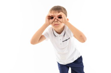 Stüdyoda beyazlara karşı poz veren sevimli çocuk.