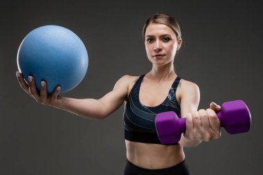 Güzel sporcu kadın griye karşı poz veriyor. 