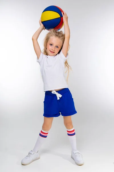 可爱的运动型小女孩拿着篮球摆姿势 — 图库照片