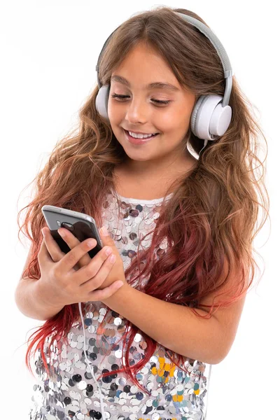 Dziewczyna Musującej Sukience Dużymi Białymi Słuchawkami Słuchającymi Muzyki Wpatrującymi Się — Zdjęcie stockowe