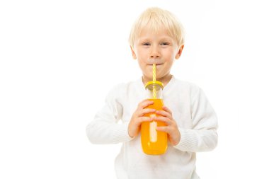 Beyaz arka planda içecekle poz veren küçük çocuk. 