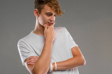 Yakışıklı duygusal çocuk stüdyoda Gray 'e karşı poz veriyor.