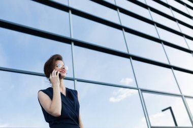Güzel bir kadın telefonda konuşuyor. 